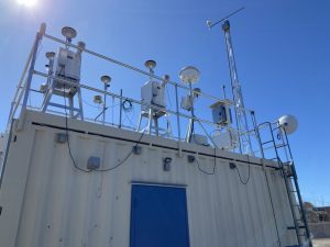 A variety of equipment sit atop a shipping container, used as an air monitoring station in Reno.