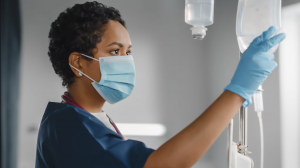 A healthcare worker reviews a bag containing IV fluid