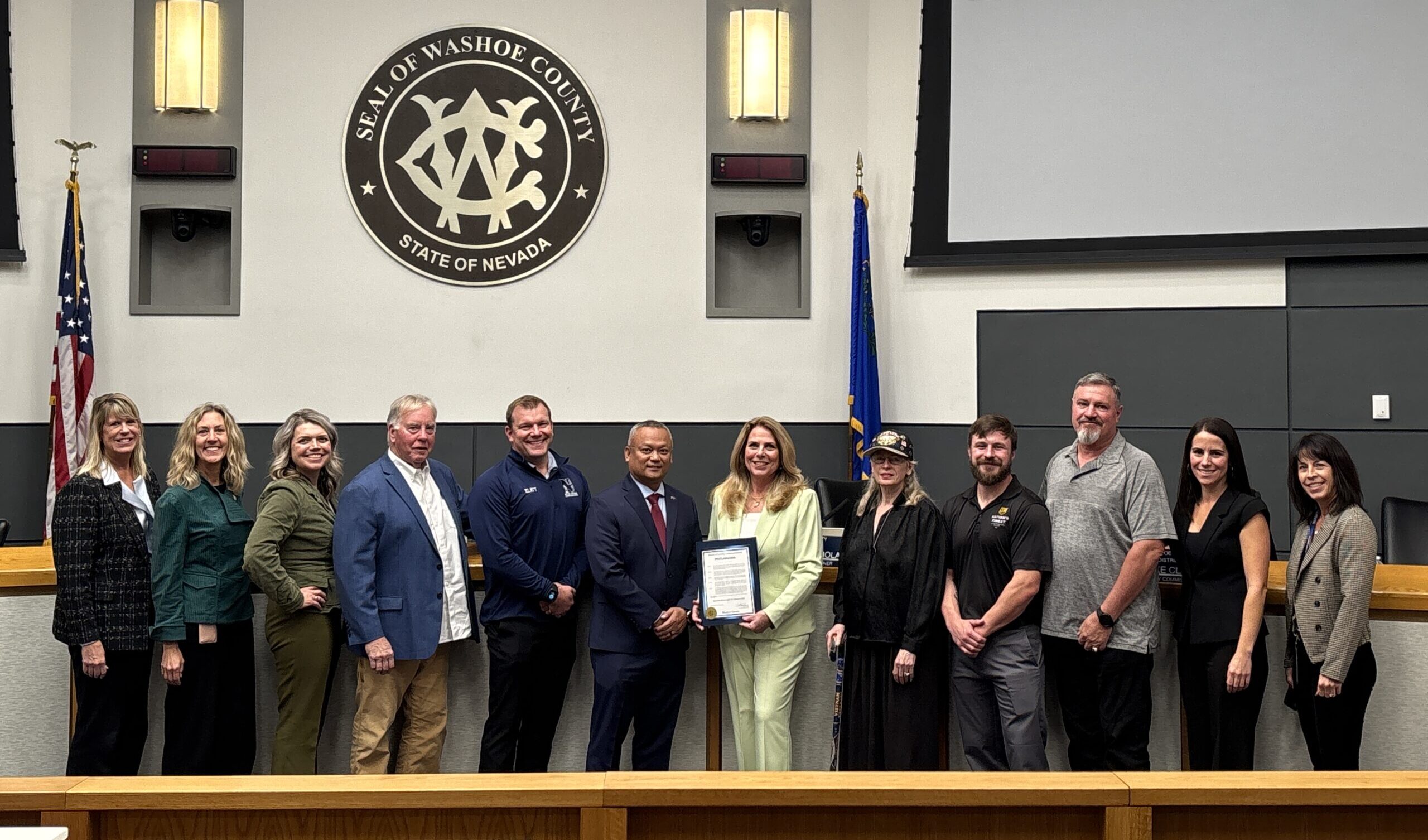 Image (1) photo of people posing in front of the Washoe County seal