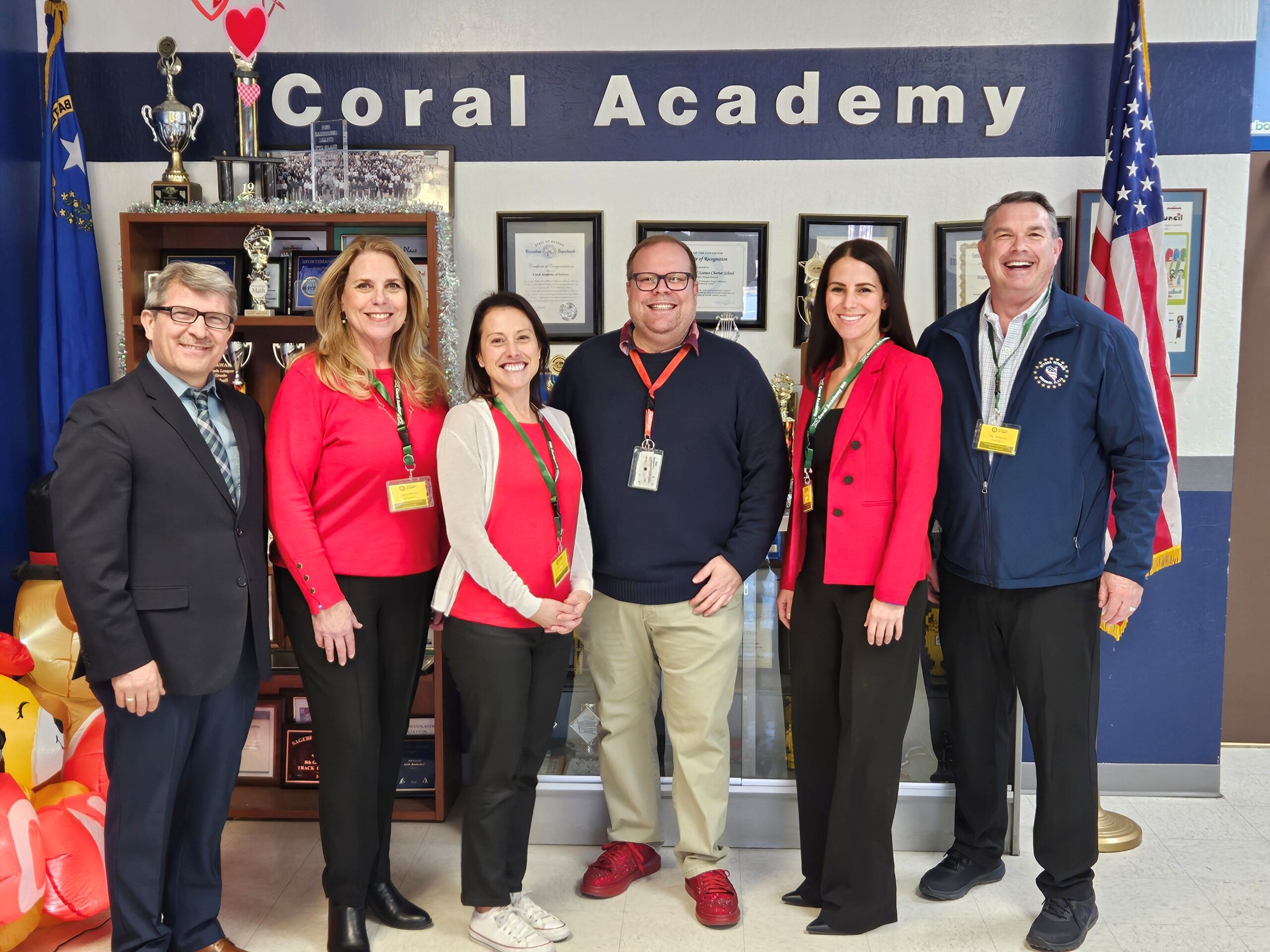 photo of people standing in front of a wall that says Coral Academy