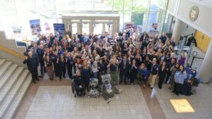 Photo of a large group of people at the Washoe County Complex posing with mascots from UNR.