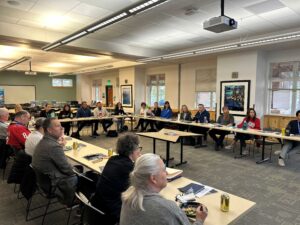 photo of people seated at tables in a conference-type setting.