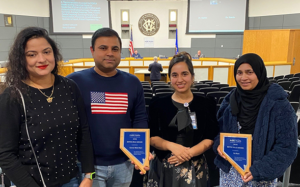 four people holding awards for the Extra Mile Award from NNPH.